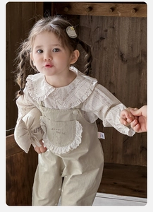 Détail de chemise florale à col claudine et salopette kaki avec broderie de lapin