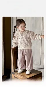 Detail of baby girl floral top with large collar and purple pants with bunny decor