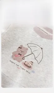 Detail of grey cotton sweatshirt featuring pink ribbed collar and cute bear print pattern