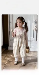 Détail de la broderie en cœur et lapin sur la salopette pour petite fille rose