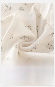 Detailed macro view showing the soft floral knit texture and breathable baby fabric quality