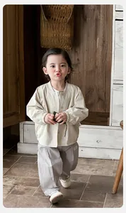 Detailed close-up of beige cotton baby jacket and gray pants with soft texture