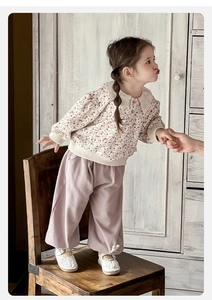 Detail of baby girl floral top with ruffled collar and soft pink trousers with bunny