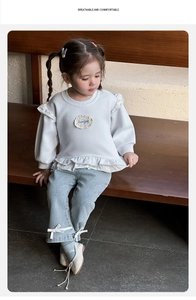 Detail of baby girl outfit with lace trim sweatshirt and bow-accented flare jeans