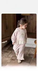 Detail of pink toddler girl knit set with floral embroidery and ruffle hem accents