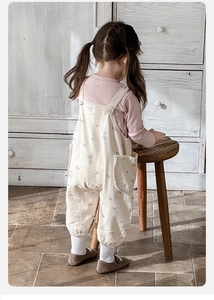 Détail d'un ensemble salopette à fleurs pour bébé fille et t-shirt rose à manches longues