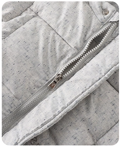 Detailed macro view of the premium resin zipper and quilted grey texture on baby winter coat