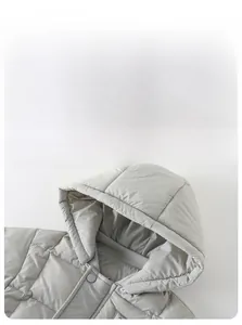 Detailed view of grey baby winter jacket showing square quilting and protective hood collar