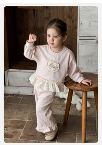Detailed view of the pink knitted cotton baby girl set with floral ruffle hem and heart patch