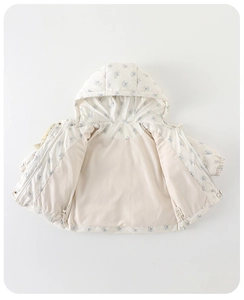 Vue détaillée d'une veste d'hiver à capuche pour bébé avec motif floral bleu sur crème