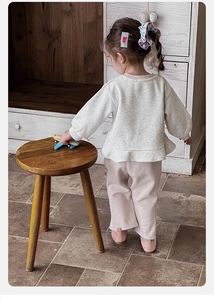 Rear view of toddler girl casual tracksuit with ruffle hem grey sweatshirt and pink pants