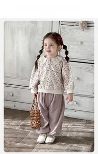 Detail of girls floral sweatshirt with lace collar and pink wide-leg pants outfit