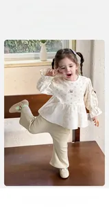 Detail of baby girl floral blouse with ruffle cuffs and corduroy flare trousers set