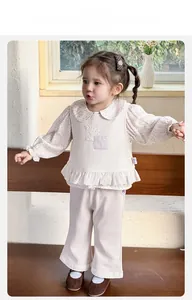 Vue détaillée de l'ensemble trois pièces pour bébé avec chemise fleurie et gilet gaufré