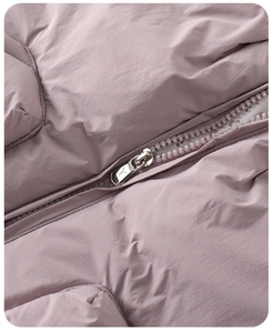 Detailed macro view of the smooth resin zipper and quilted fabric on the purple puffer jacket