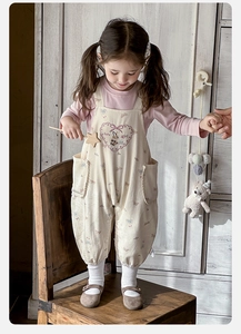 Détail de la salopette à fleurs pour bébé fille et du haut à manches longues avec dentelle