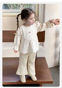 Detail of floral baby girl blouse with bow cuffs and matching flared corduroy pants