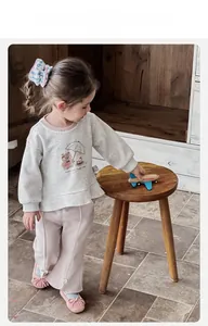 Detail of toddler girl outfit featuring a grey sweatshirt with bear print and pink pants