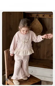 Detail of pink toddler girl loungewear set with floral ruffle hem and soft round neck top