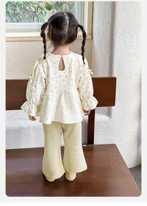 Detail view showing back button closure and yellow bow on baby girl floral blouse