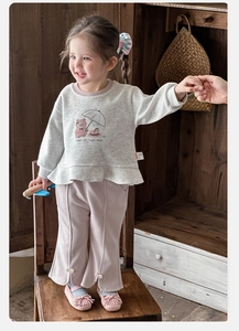 Close-up of girls' ruffle hem sweatshirt with bear print and pearl bow flare pants