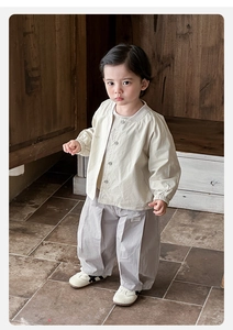 Detail of beige utility jacket and grey pleated wide-leg trousers for toddlers