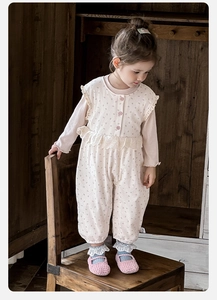 Détail de la salopette à fleurs et chemise à manches longues en gaufre pour bébé fille