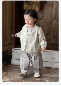 Detail of baby spring outfit featuring mushroom embroidery and wide-leg cotton pants