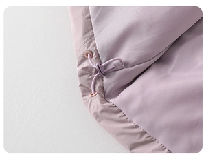 Detail of adjustable drawstring toggle on purple puffer jacket for toddlers