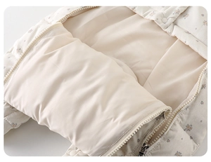Macro detail of infant floral romper featuring smooth beige lining and secure snap buttons