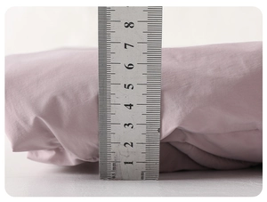 Detail view showing 4.5cm thickness of infant winter down jacket with a measuring ruler