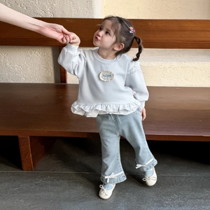Infant girl two-piece outfit featuring a grey ruffled sweatshirt and blue bow-detail jeans