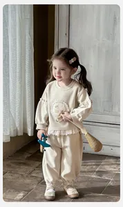Détail d'un ensemble sweat bébé beige pour fille avec dentelle et broderie lapin