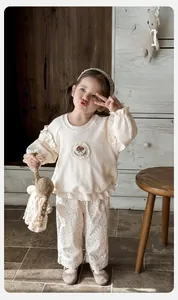 Détail d'ensemble bébé avec broderie champignon et pantalon à fleurs mignon