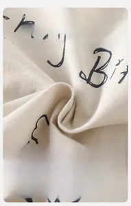 Close-up of soft beige knit fabric with Happy Birthday lettering for baby clothing