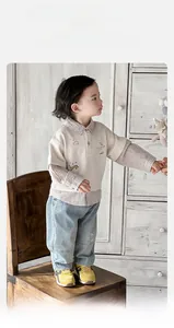Detail of baby boy faux two-piece polo shirt and jeans set with cute embroidery