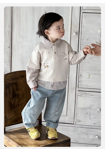 Detail of baby boy faux two-piece plaid polo shirt and washed blue denim jeans set