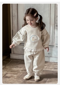Détail du sweat-shirt pour bébé fille avec bordures en dentelle et broderie de lapin