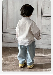 Detail of baby boy faux two-piece plaid shirt and loose denim pants outfit back view