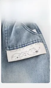 Close-up of light blue washed denim jeans pocket with cute animal prints and text