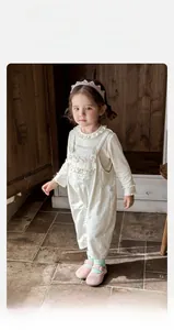 Close-up of baby girl floral overalls with lace collar top and breathable cotton fabric