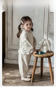 Détail de l'ourlet à volants en dentelle et broderie sur le sweat-shirt en coton pour bébé