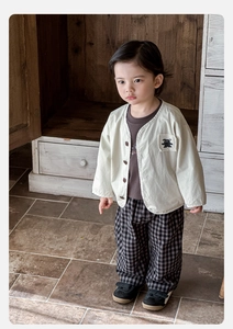 Detail of baby boy cardigan with cartoon patch and classic checkered trousers set