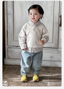 Detail of baby boy faux two-piece polo shirt with plaid trim and denim pants set