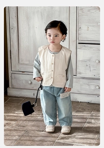 Detail of baby boy vest outfit with light blue shirt and washed denim trousers