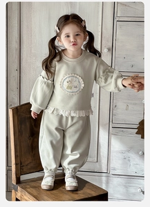Détail d'un ensemble de sweat-shirt pour bébé fille avec broderie lapin et bordure en dentelle