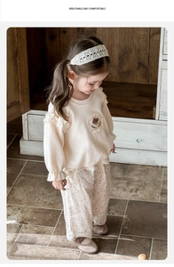 Détail de l'ensemble bébé fille avec sweat crème à dentelle et pantalon floral