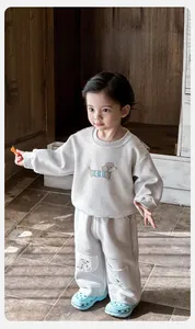 Detailansicht hellgraues Baby-Sweatshirt mit niedlichem blauem Cartoon-Hundemotiv