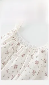 Close-up of baby girl floral dress showing elastic neckline and cotton texture detail