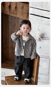 Detail of baby boy plaid jacket set with white tee and black casual trousers